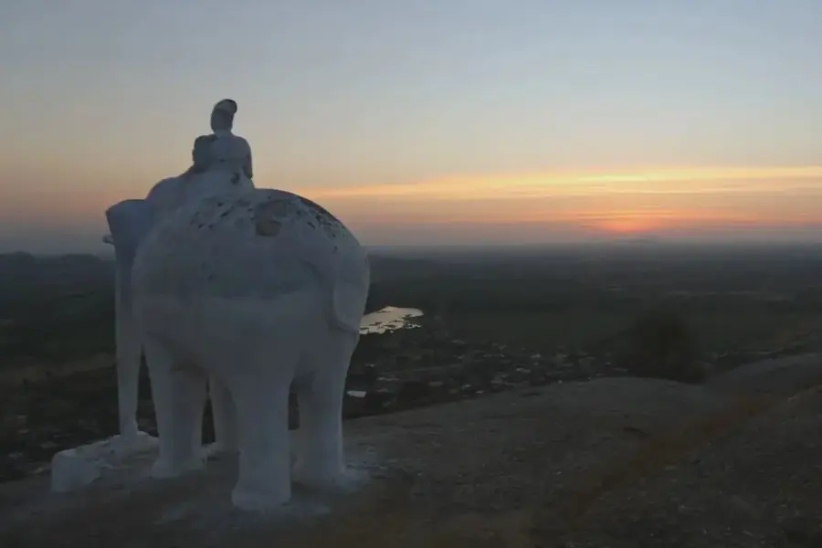 La statua dell'elefante con il suo cavaliere sulla collina di Narlai, in controluce contro il cielo del tramonto