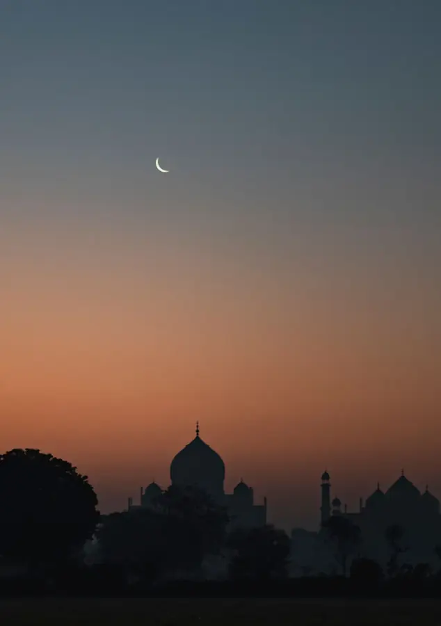 La sagoma del Taj Mahal al crepuscolo, con una falce di luna nel cielo