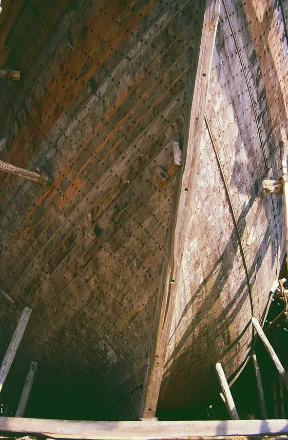 Lo scafo di legno di un uru visto dal basso, con le tavole inchiodate a mano, nel cantiere di Beypore