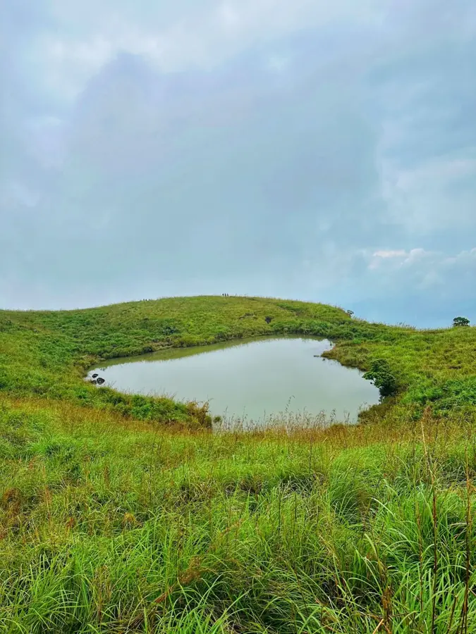 Il piccolo lago a forma di cuore tra l'erba alta sui pendii del Chembra